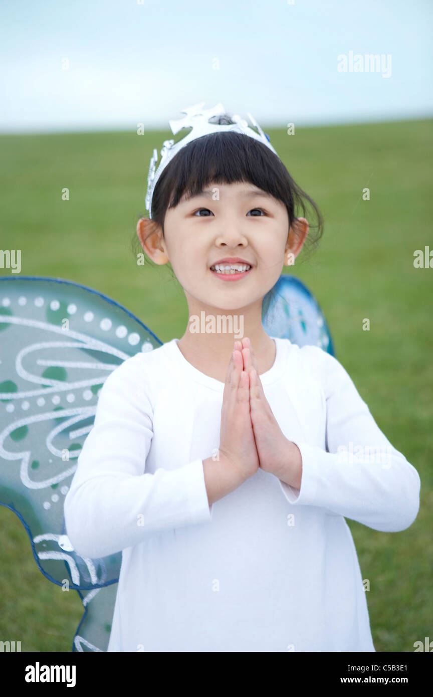 Close-up of girl wearing crown and wings Stock Photo