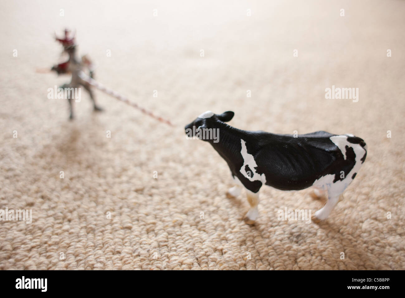 Toy cow and figure on carpet Stock Photo