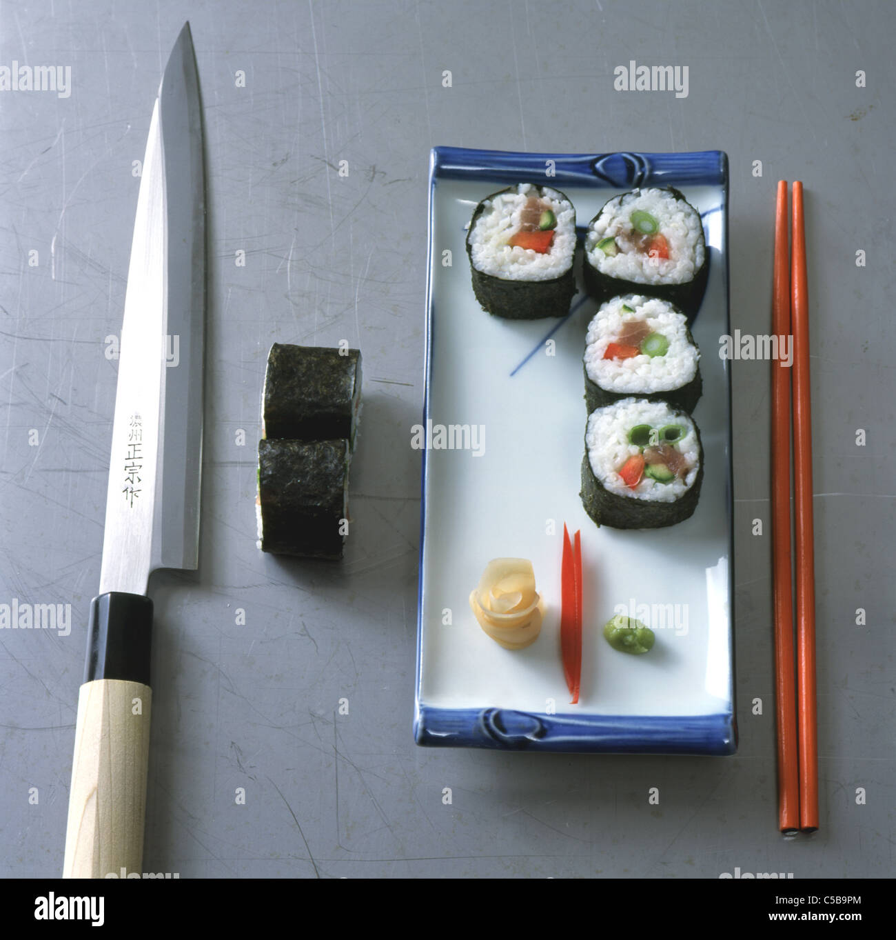 Futomaki Sushi: Cutting the role into slices, serving Stock Photo