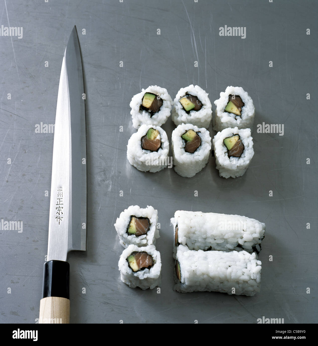 Uramaki Sushi: Cutting the role into slices Stock Photo - Alamy