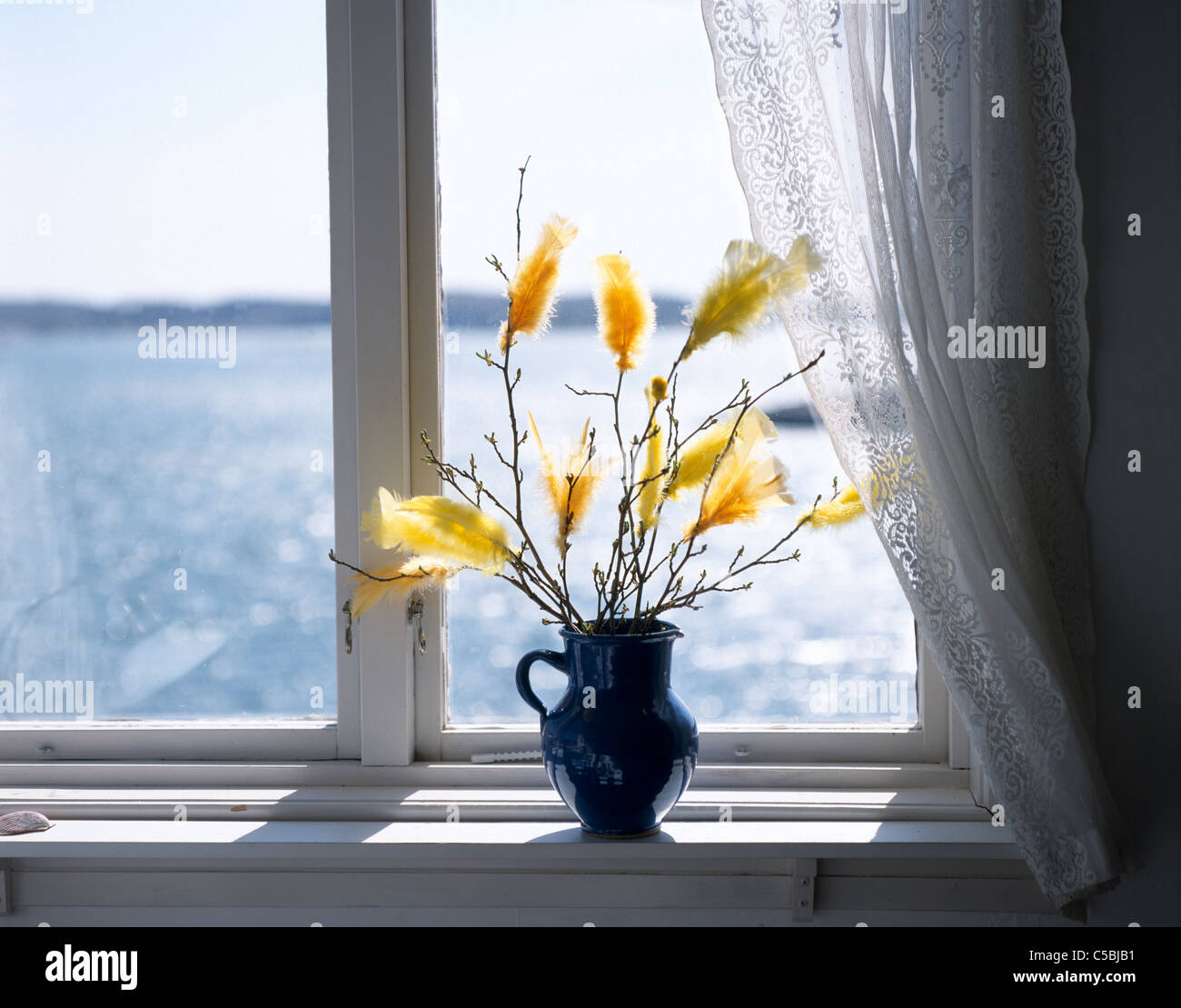 Easter Decoration With Feathers In Vase On Window Sill Stock Photo