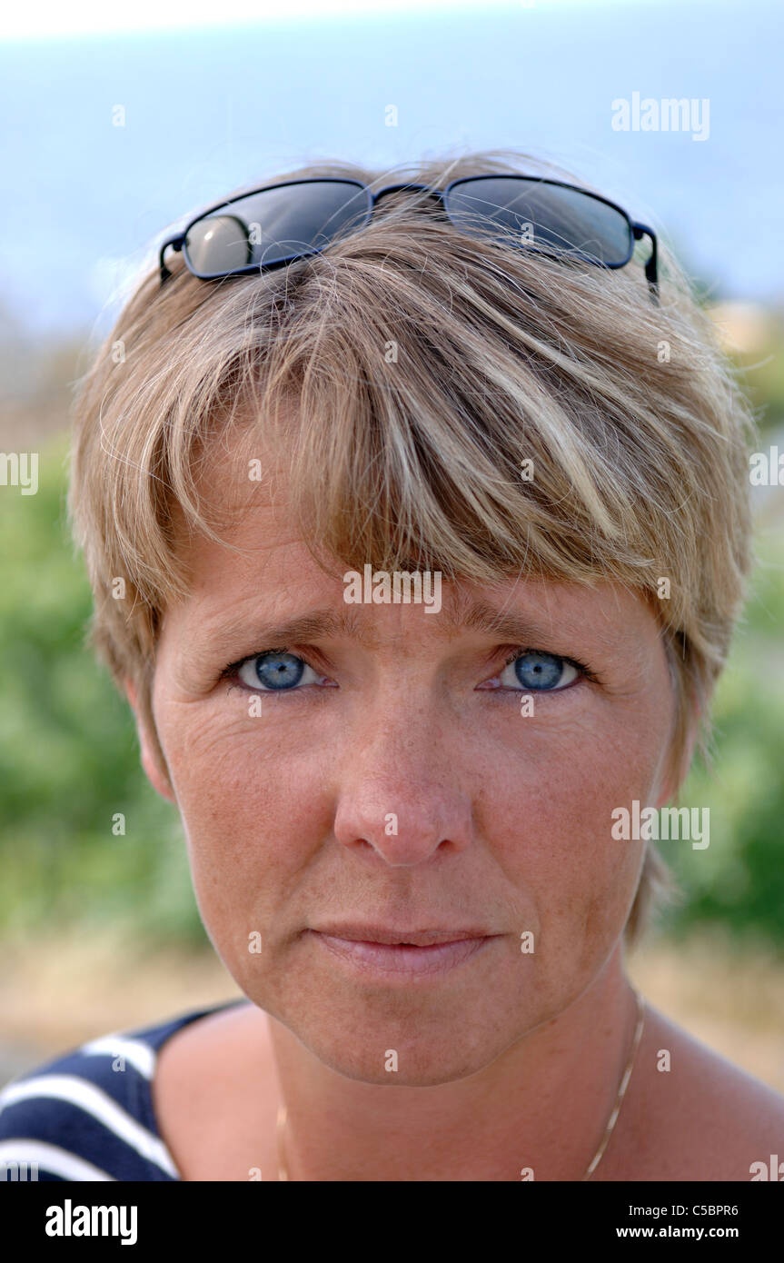 Extreme close-up portrait of a serious woman with short blond hair ...
