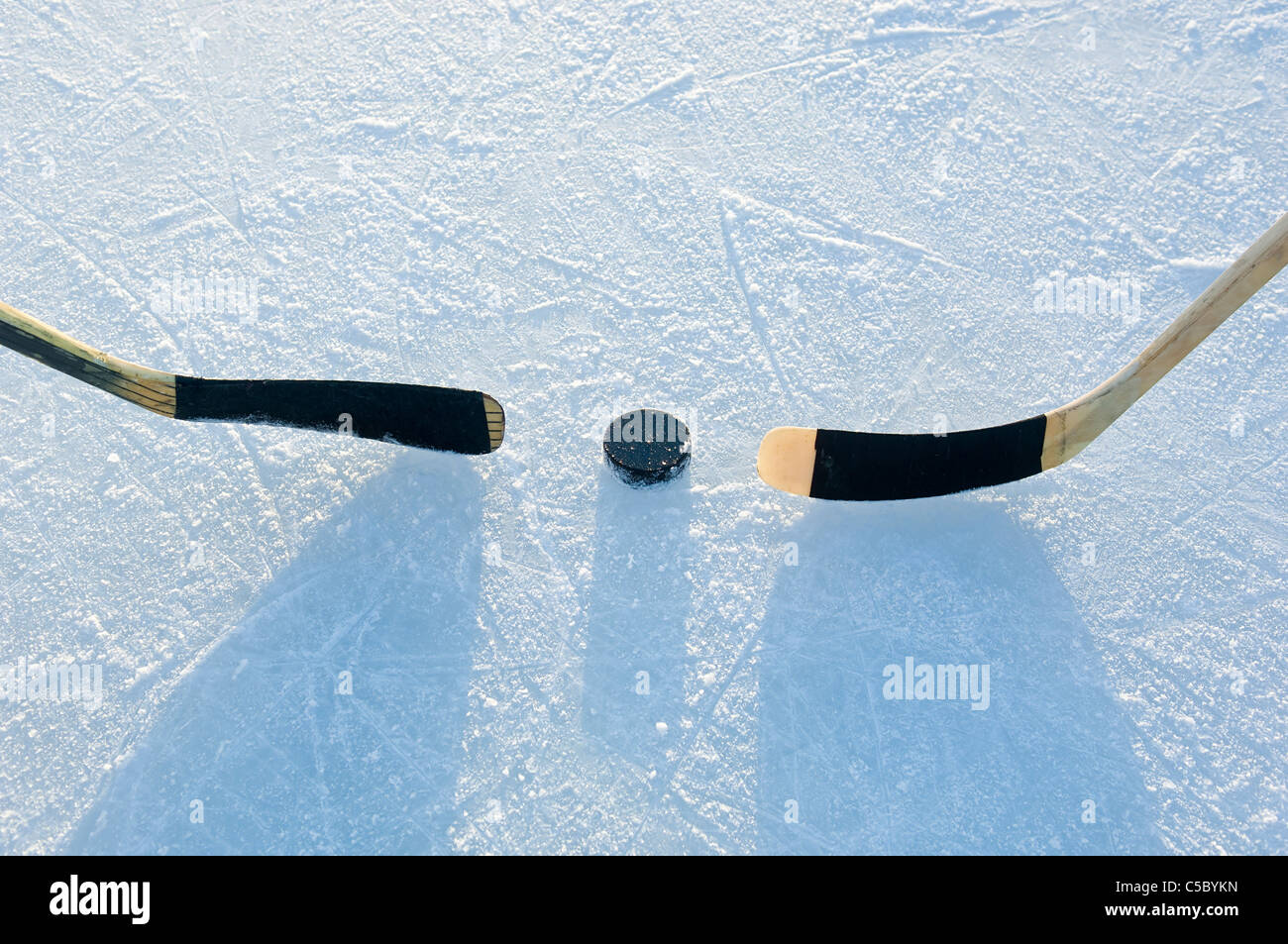 hockey puck and stick on ice