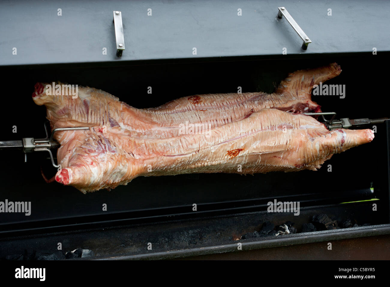 Hog roast cooking on a spit Stock Photo