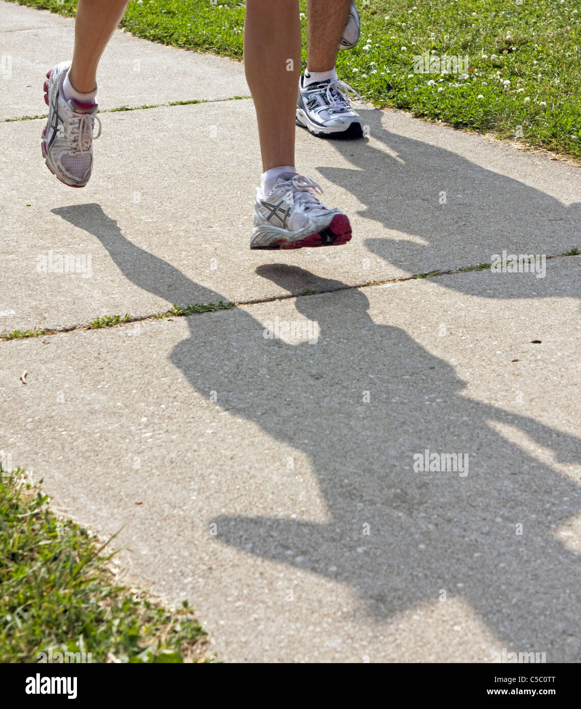 Runners cast shadows on a hot morning as they run a 1/2 marathon in