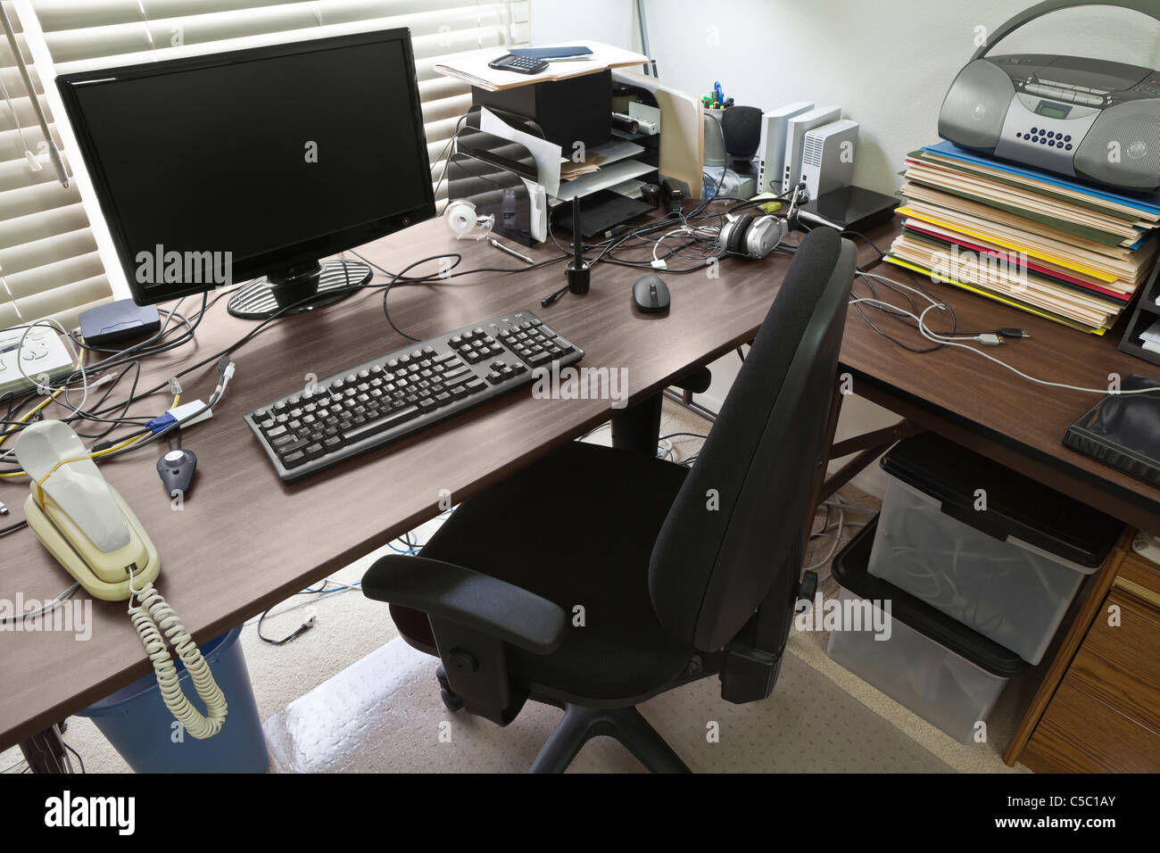 Busy, cluttered, home office table desk. Stock Photo