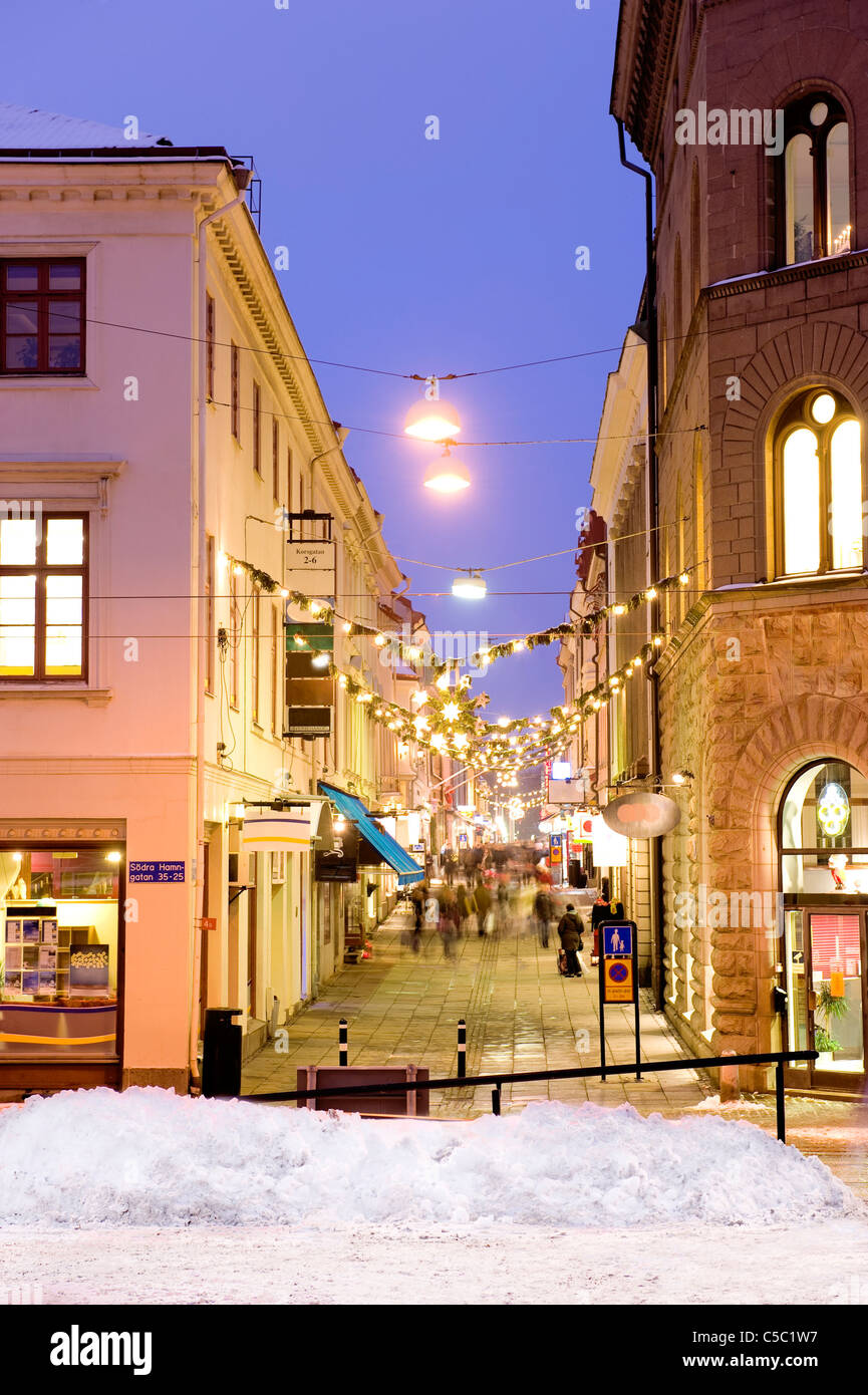View of Christmas shopping at cross street along buildings at dusk Stock Photo