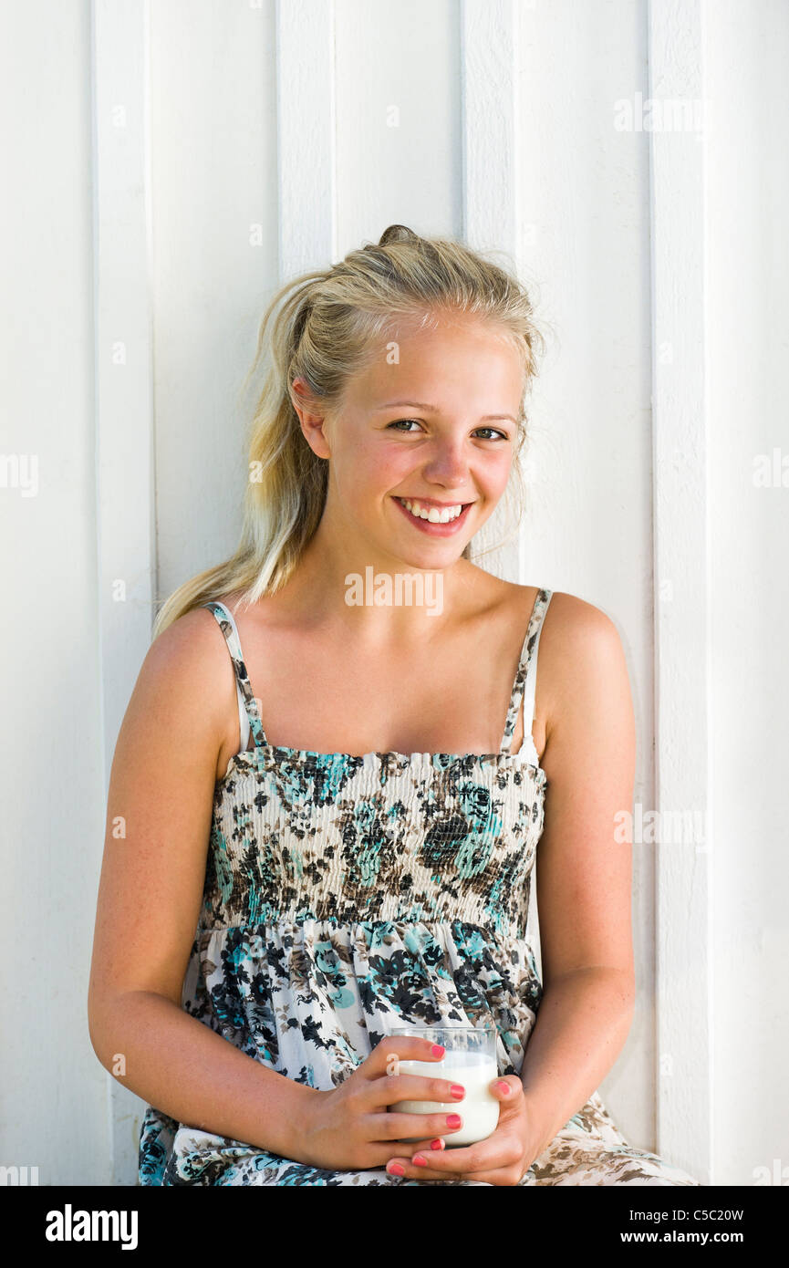 Portrait of a teenage blond girl with milk glass smiling Stock Photo