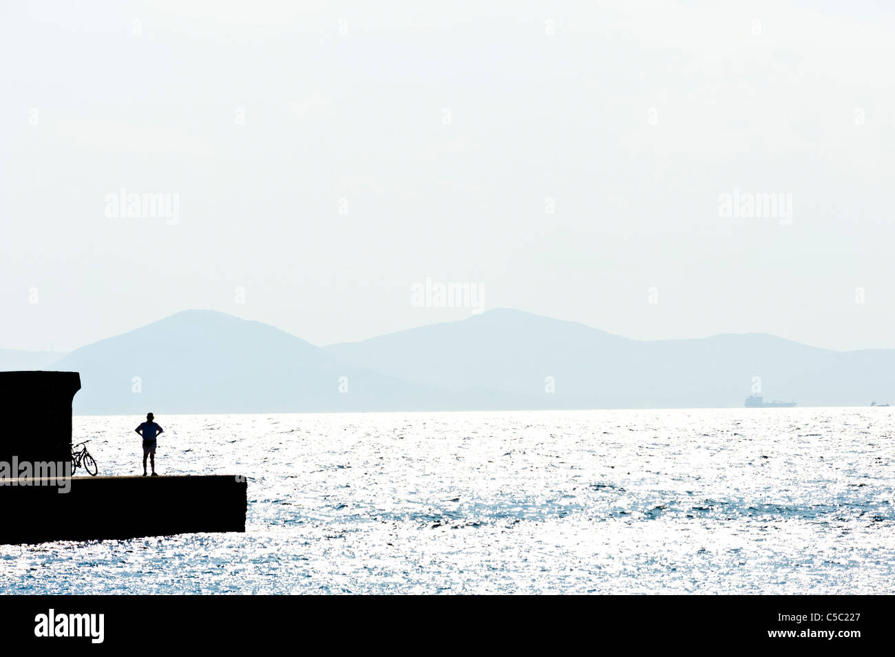 Glittering peaceful sea with a silhouette man Stock Photo