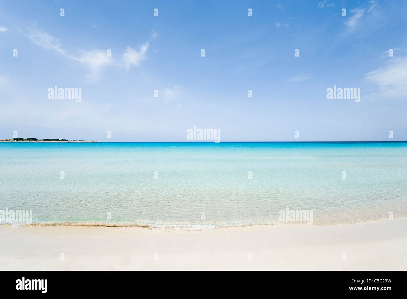 Sandy beach with clear water below blue sky at Sicily Stock Photo