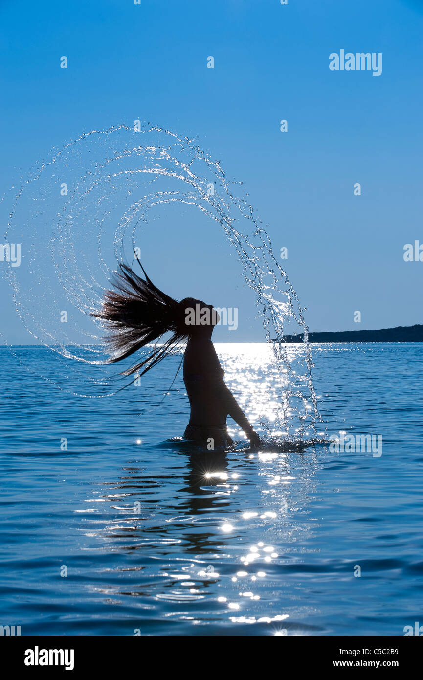 Silhouette of a young long haired woman in the back light hires stock