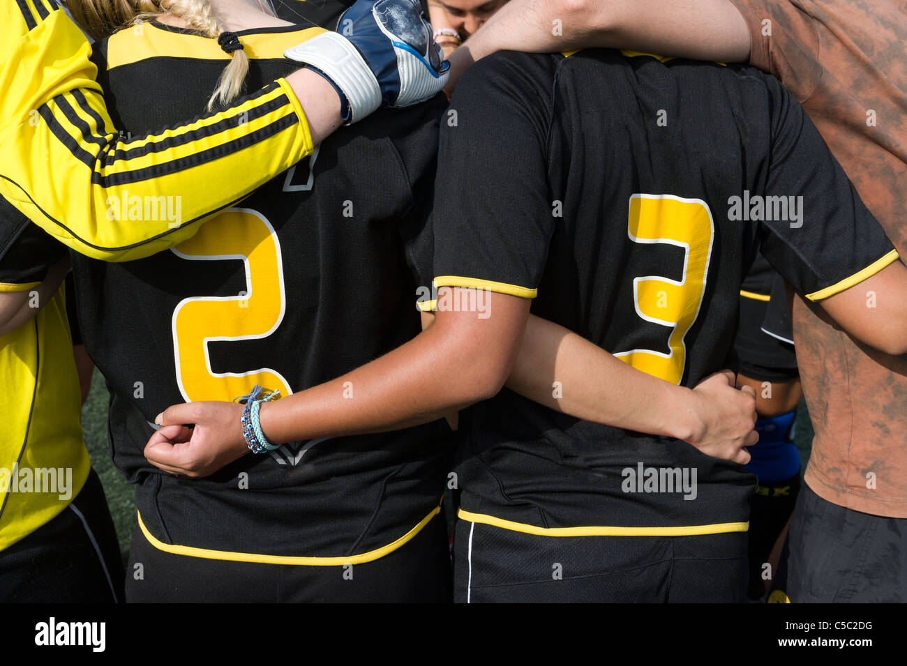 Close-up midsection of football players with arms around before the game Stock Photo