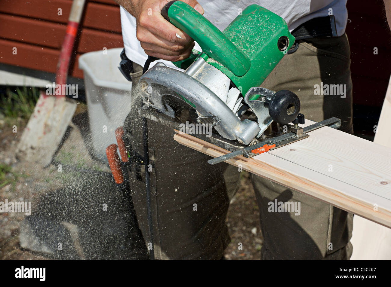 Close-up of a carpenter sawing board with a circular saw Stock Photo