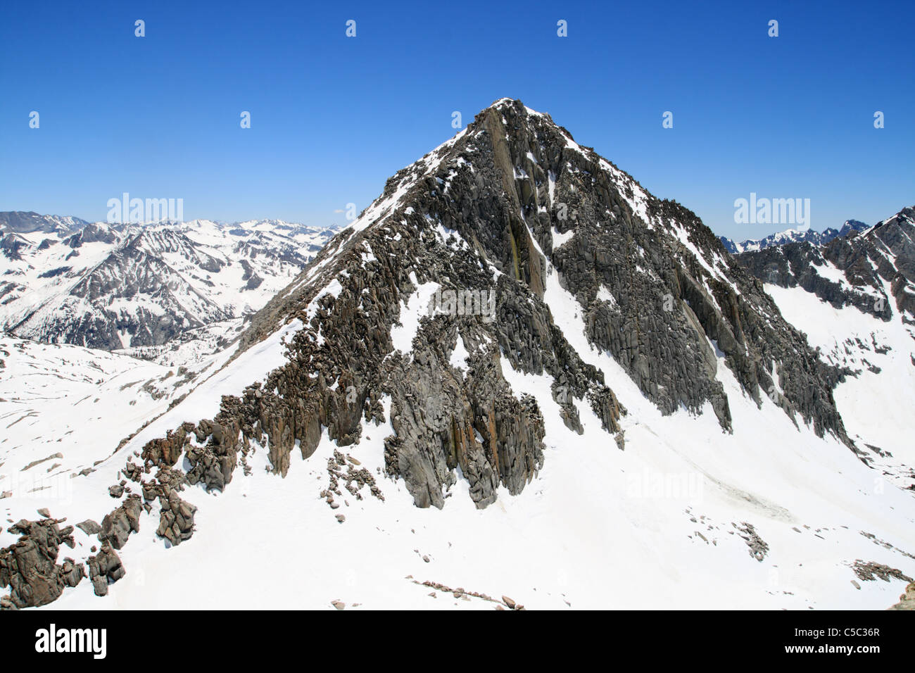 Columbine Peak in the Sierra Nevada viewed from Isosceles Peak in snowy early summer conditions Stock Photo