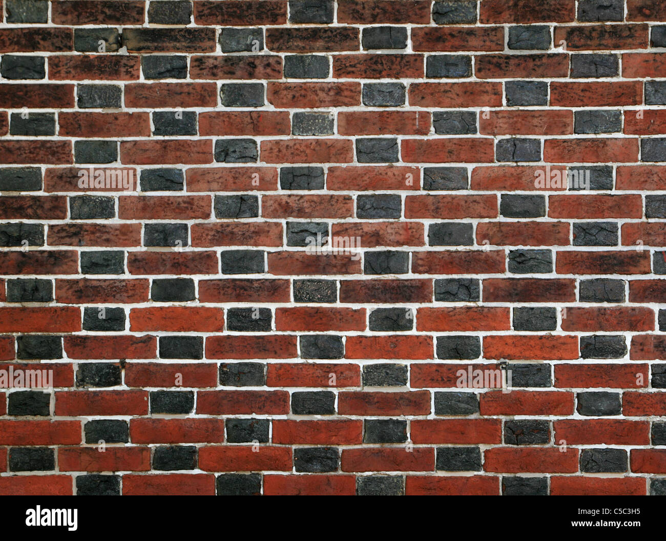 red and black brick wall with white mortar Stock Photo