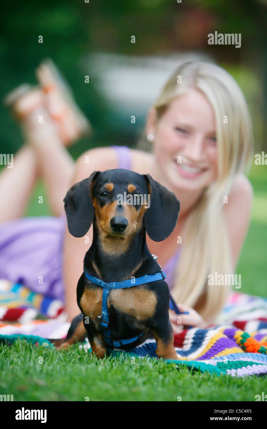 Woman Relaxing With Her Miniature Dachshund; Victoria, Vancouver Island, British Columbia, Canada Stock Photo