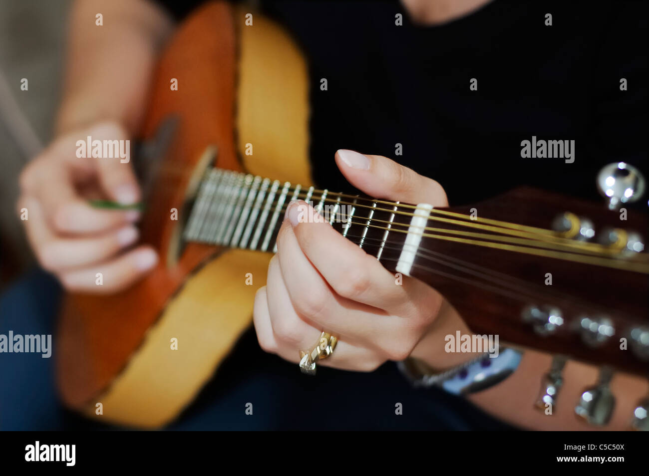 Female mandolin player sits and plays a ditty. Custom made mandolin