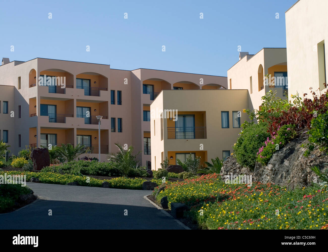 Road leading to hotel buildings against clear sky at Fuerteventura, Spain Stock Photo