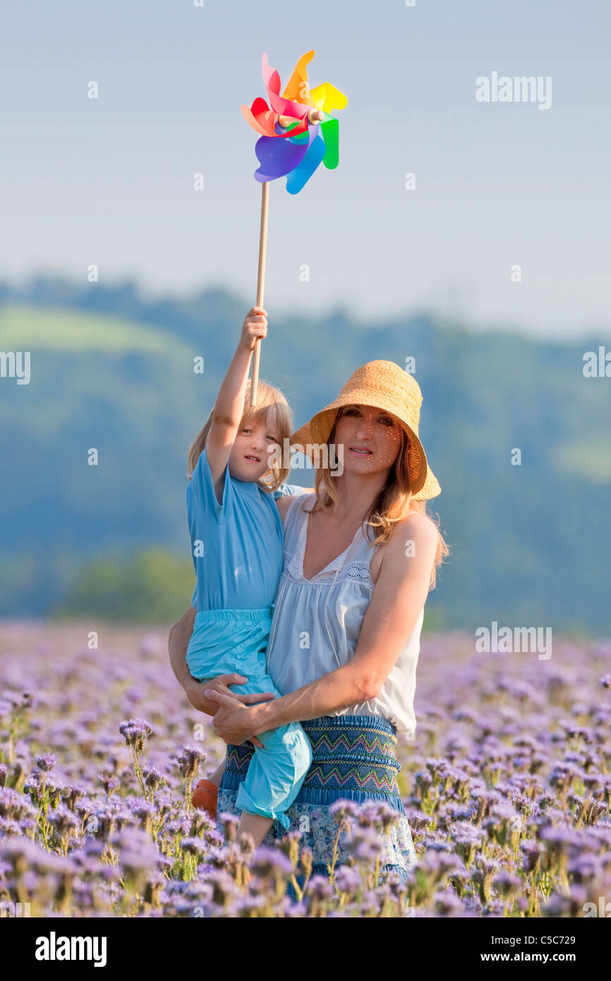 portrait of mother and son playing with pinwheel in a field Stock Photo ...