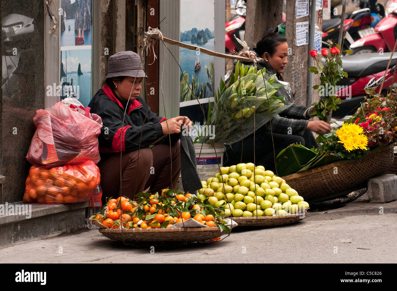 Street hawkers selling fruit and flowers, Hang Bac St, Hanoi Old Quarter, Vietnam Stock Photo