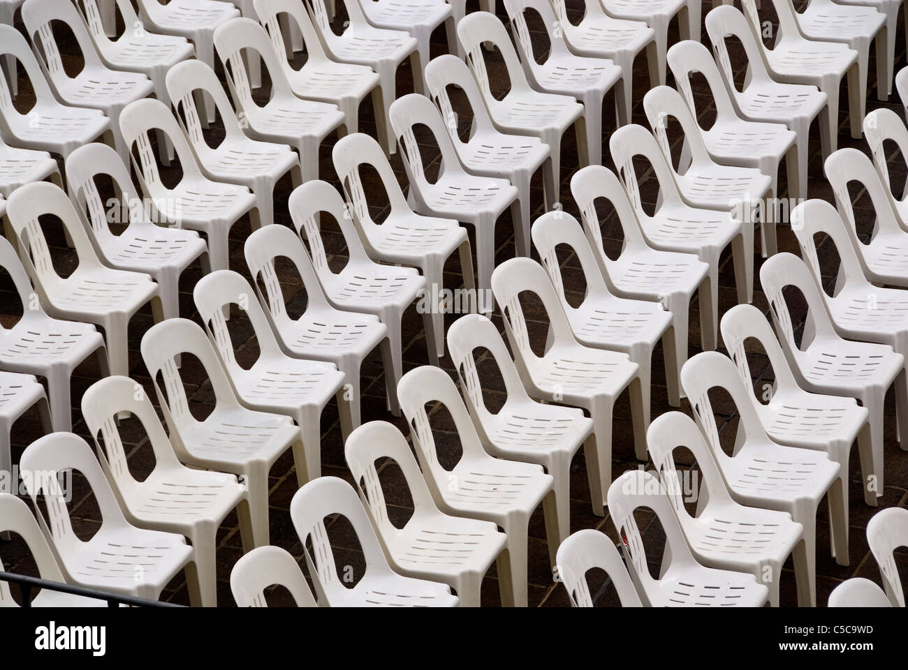 Rows of white plastic stacking chairs Stock Photo Alamy