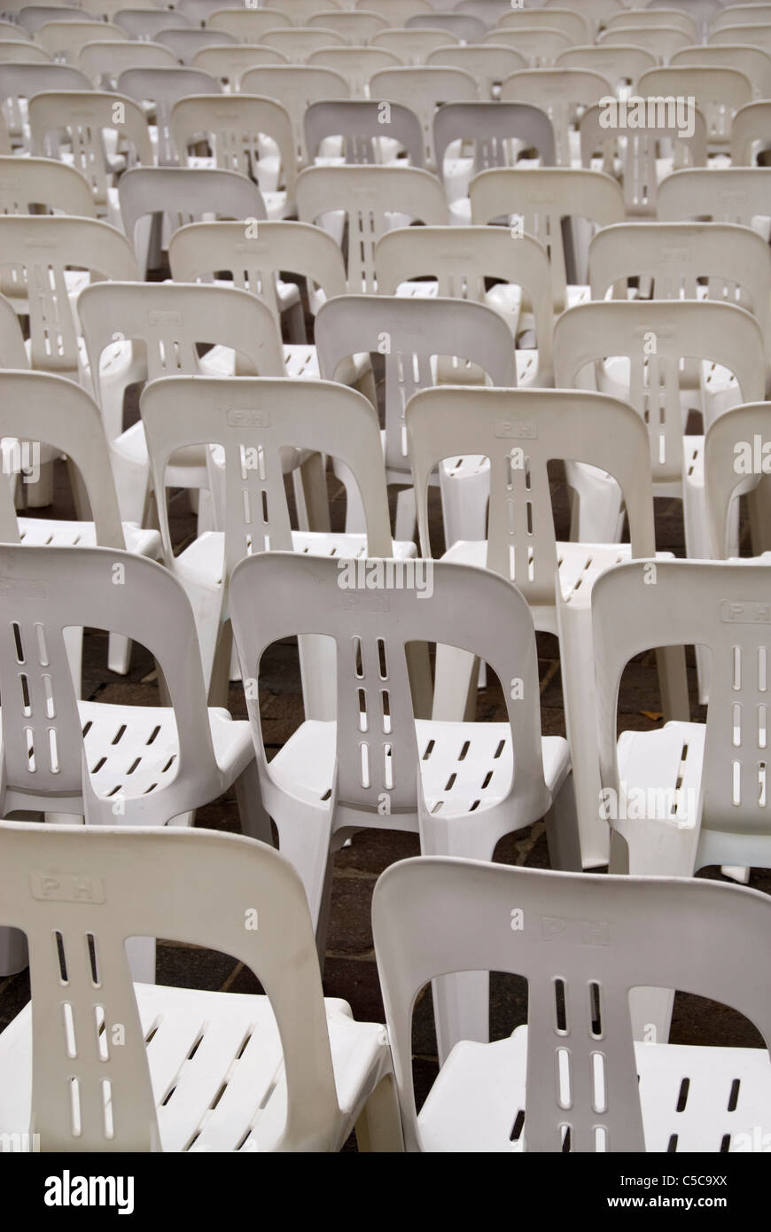 Rows of white plastic stacking chairs Stock Photo Alamy