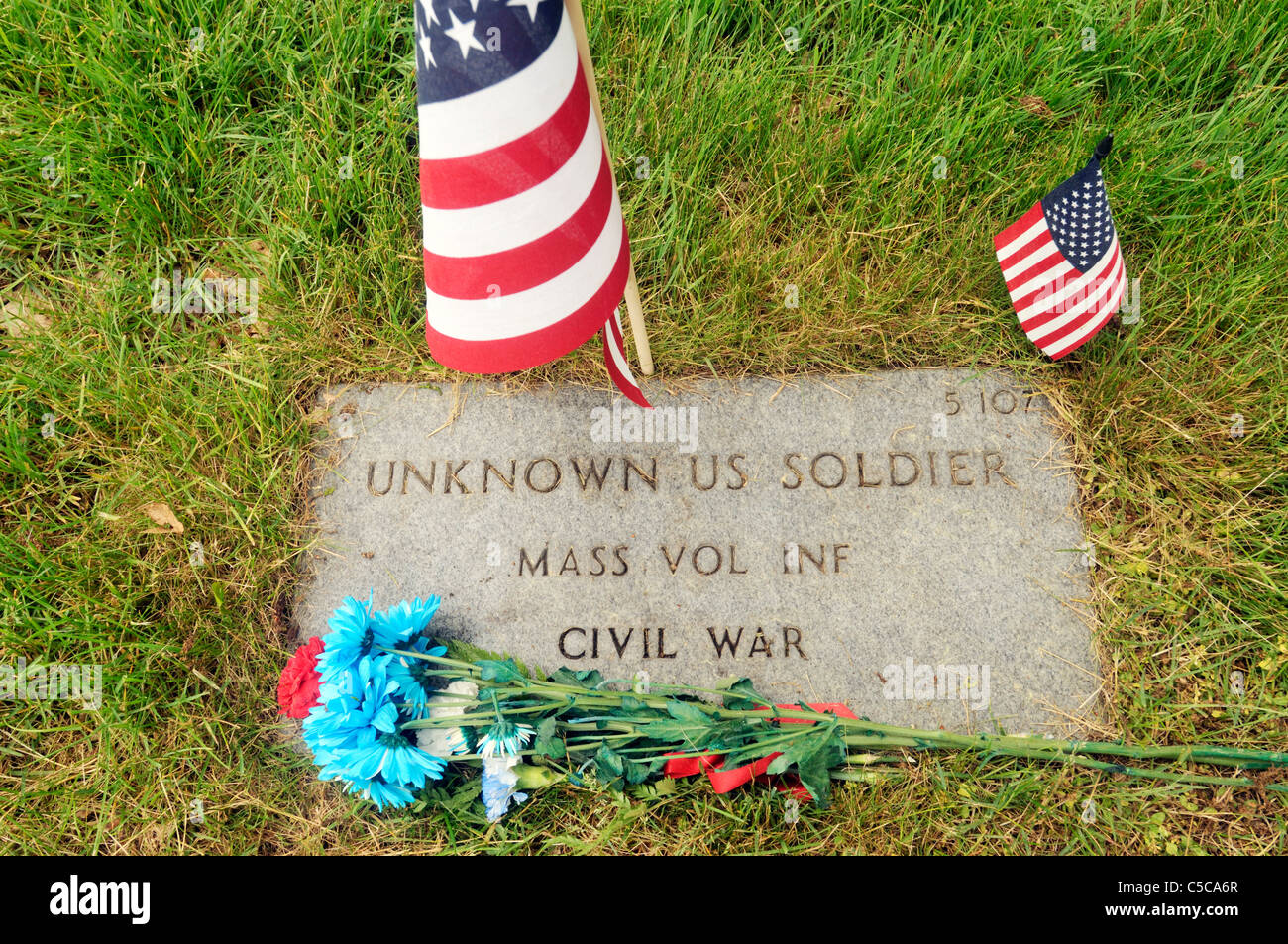Grave marker of an unknown civil war soldier with flags and flowers