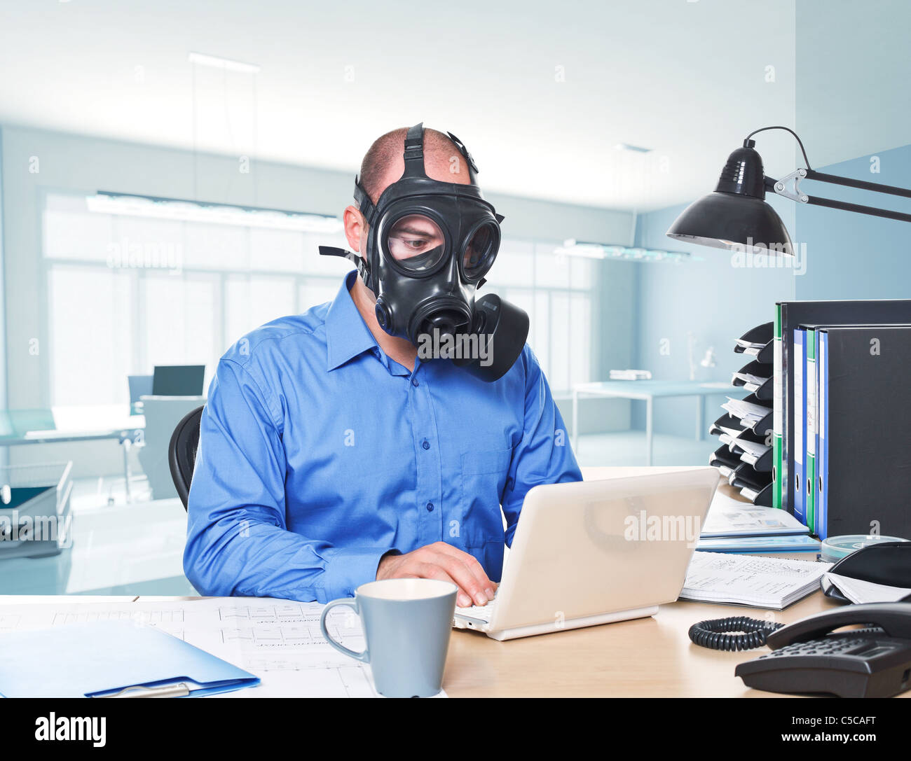 man-wearing-gas-mask-work-with-laptop-C5CAFT.jpg