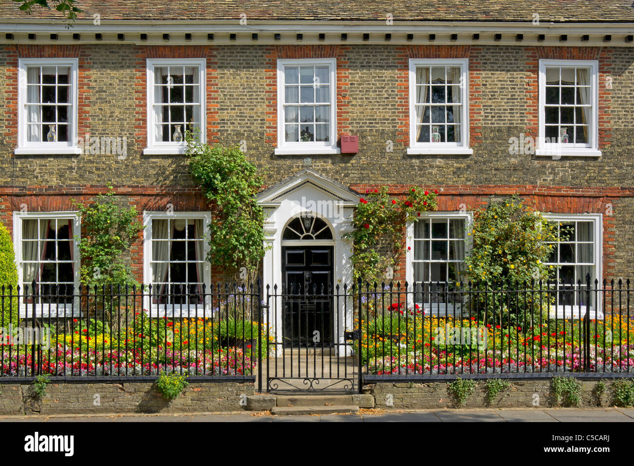 An old house with floral summer border on Palace Green by the Cathedral in Ely, Cambs Stock Photo