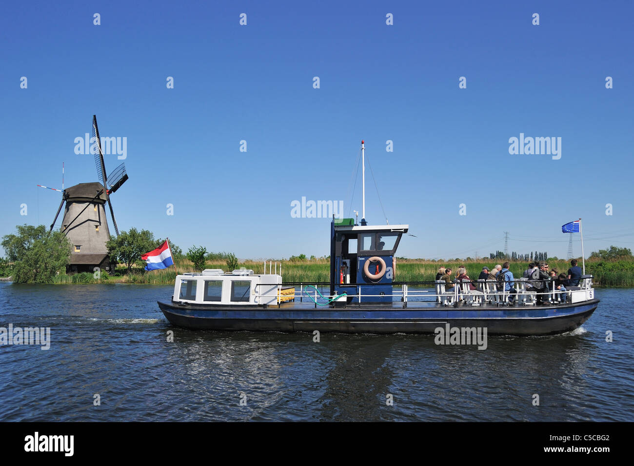 Tourists on sightseeing boat and thatched polder windmills at Kinderdijk, South Holland, the Netherlands Stock Photo