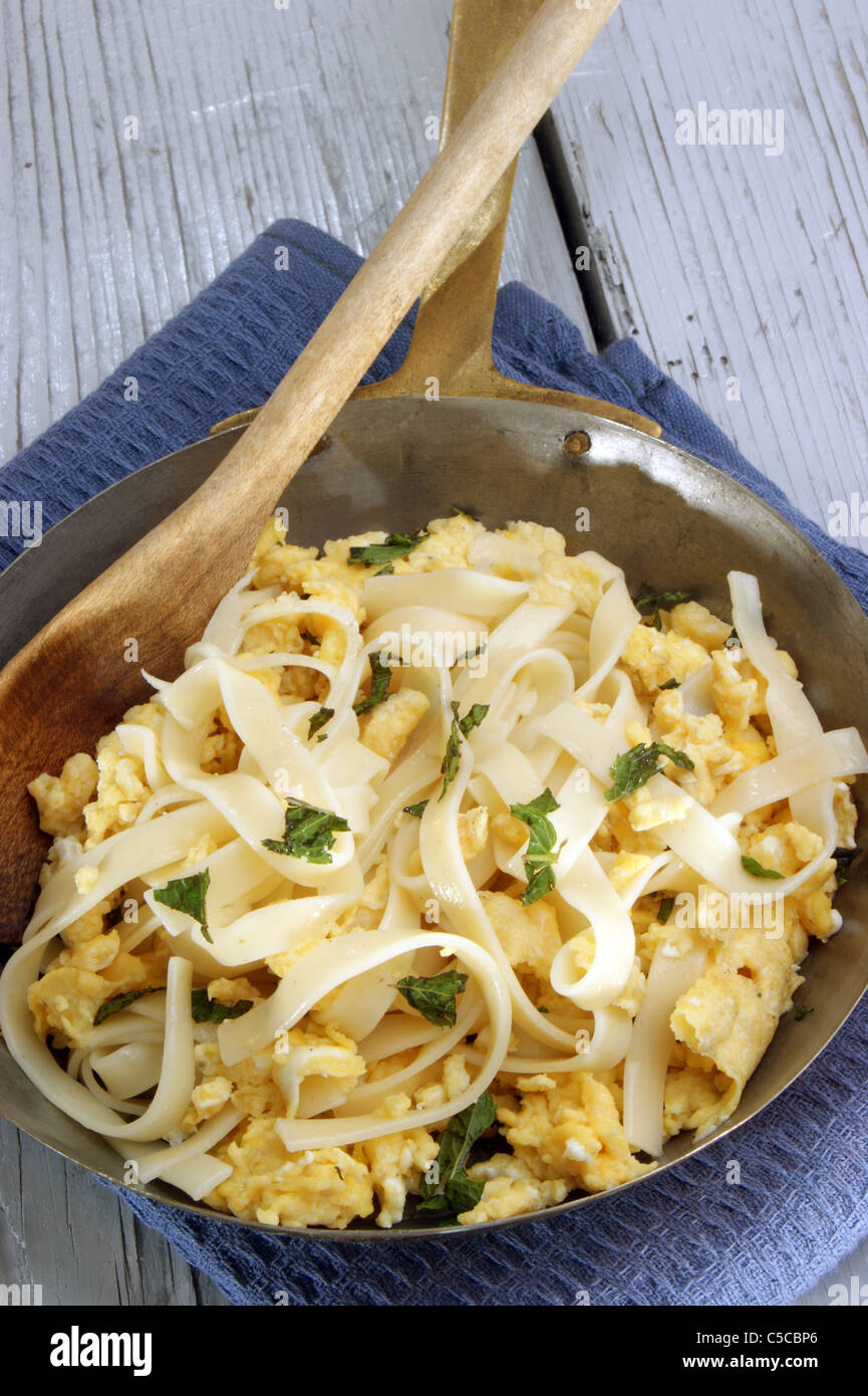Scrambled eggs and homemade tagliatelle in a brass pan Stock Photo Alamy