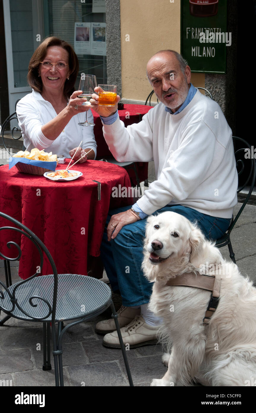 Middle-aged Italian couple and their dog enjoying La Dolce Vita at a cafe in Como Stock Photo