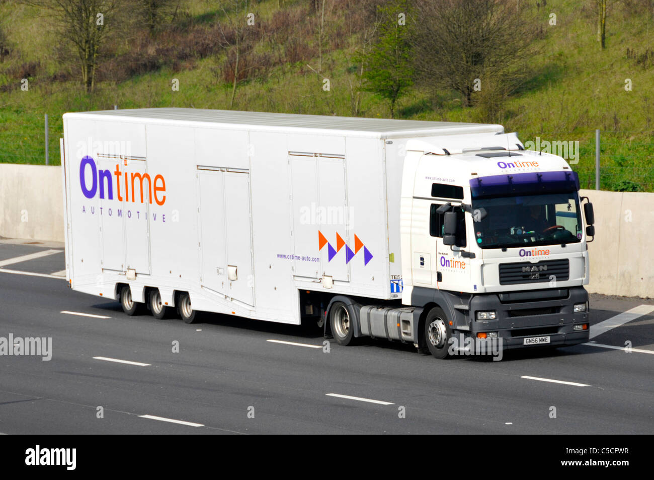 Front & side view of Ontime Automotive enclosed car delivery transport business hgv lorry truck & trailer with company logo driving on UK motorway Stock Photo