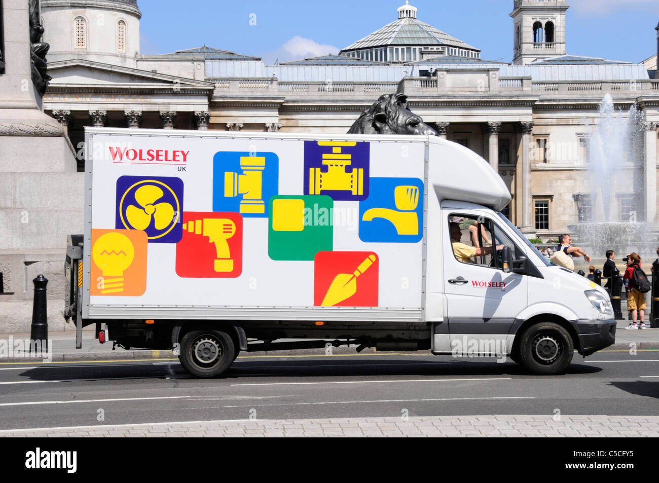 Wolseley delivery van & driver with graphic icons as mobile advertising of builders merchant business range of products Central London England UK Stock Photo
