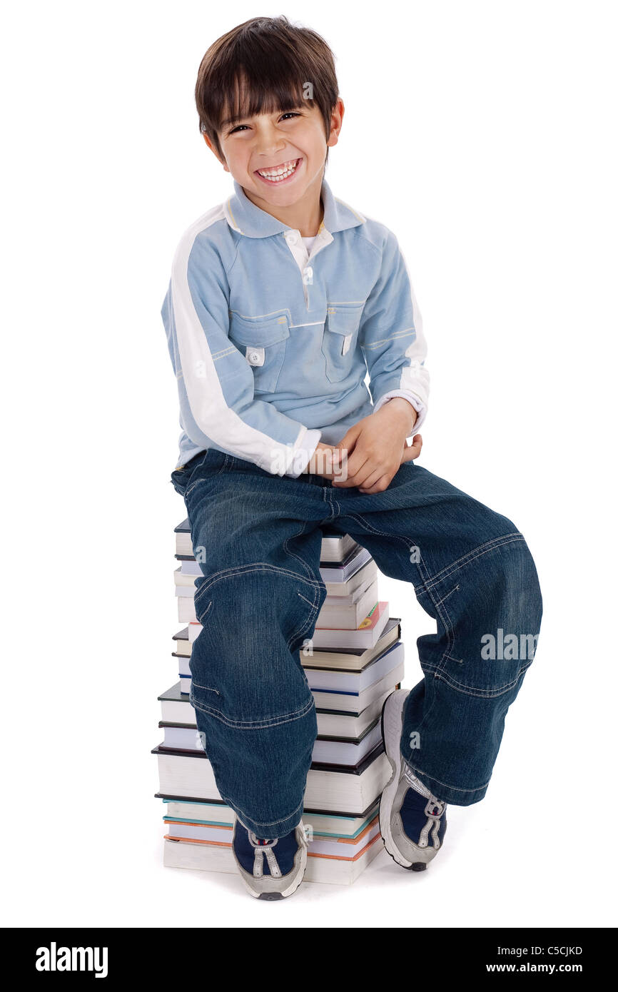 Smiling young kid sitting over pile of books on isolated white background Stock Photo