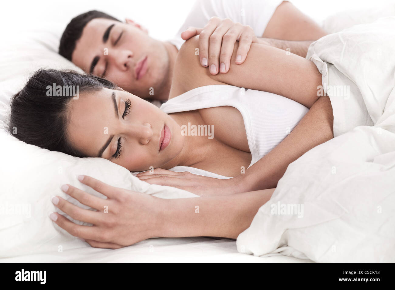 Couple lying in bed sleeping together over white background Stock Photo