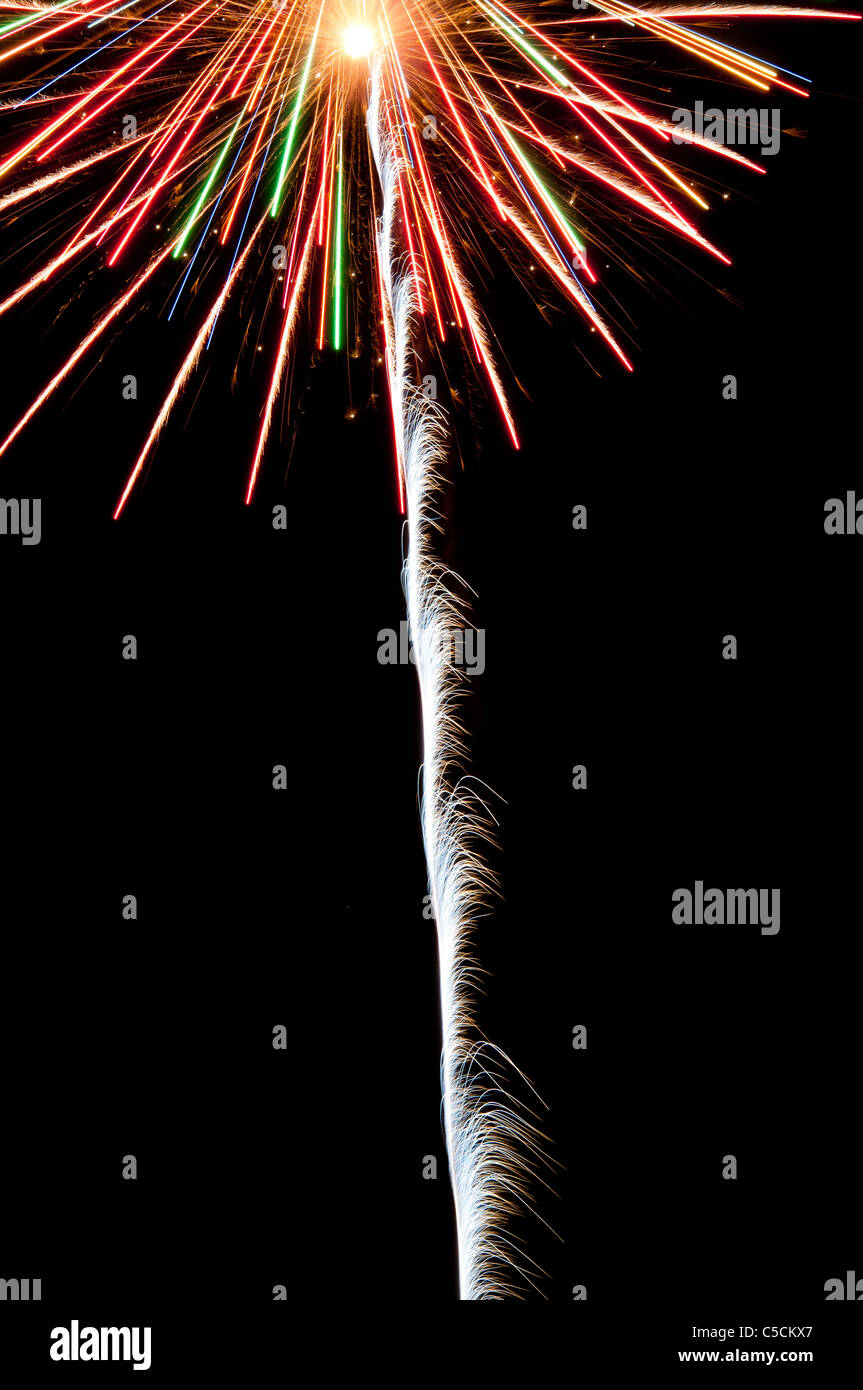 Red, green white and orange fireworks exploding in the night sky. A celebration of  color and explosions! Stock Photo