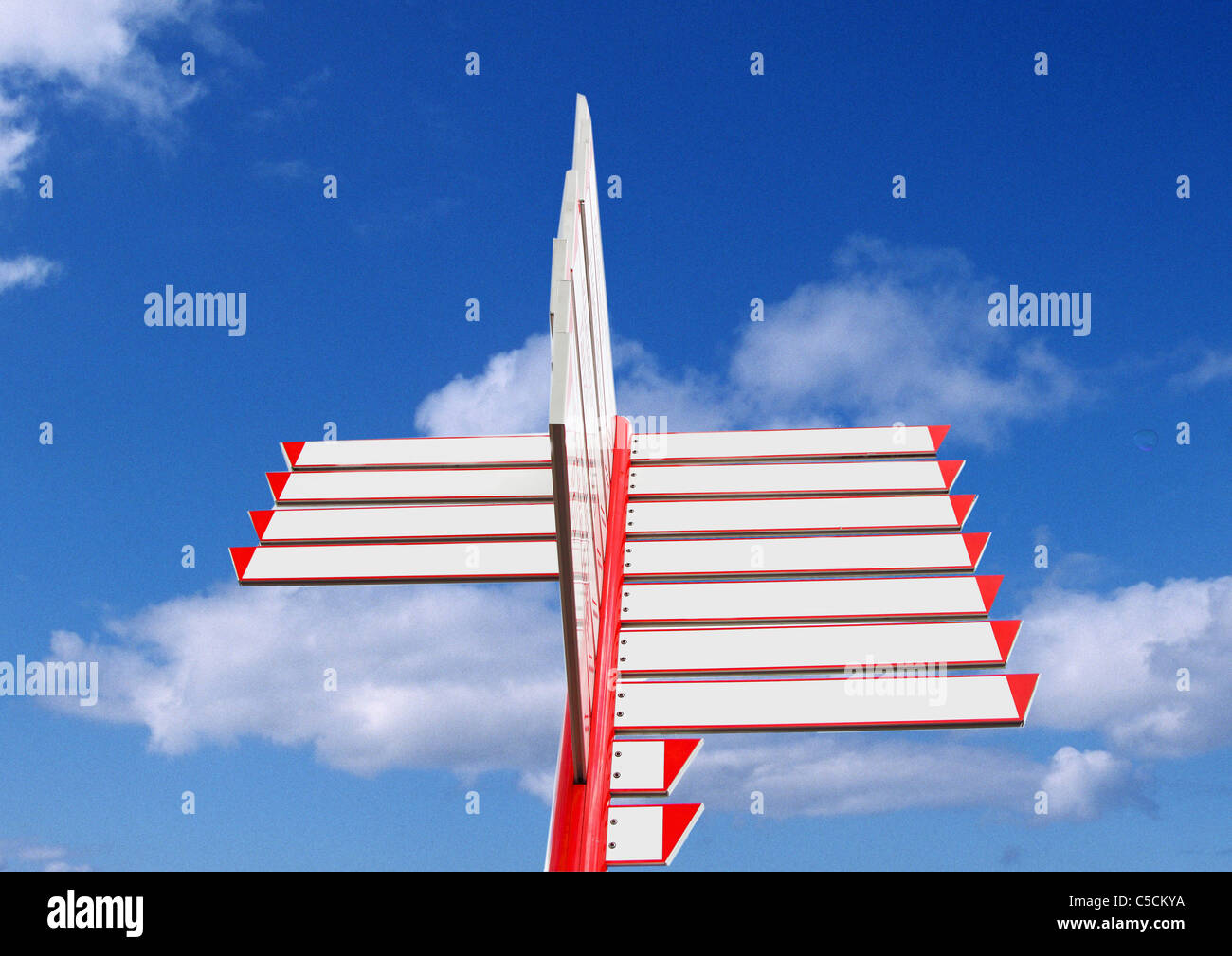 Signpost,  with empty fields, posting in different directions, blue sky, white clouds. Stock Photo