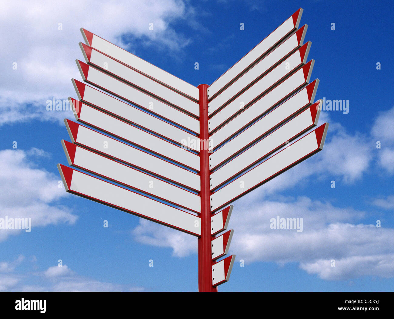 Signpost,  with empty fields, posting in different directions, blue sky, white clouds. Stock Photo