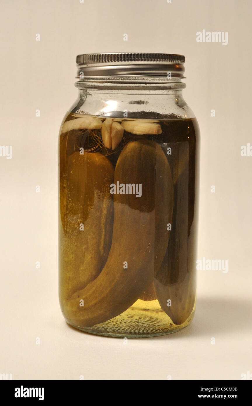A jar of home made canned pickles sits on a white background. Stock Photo