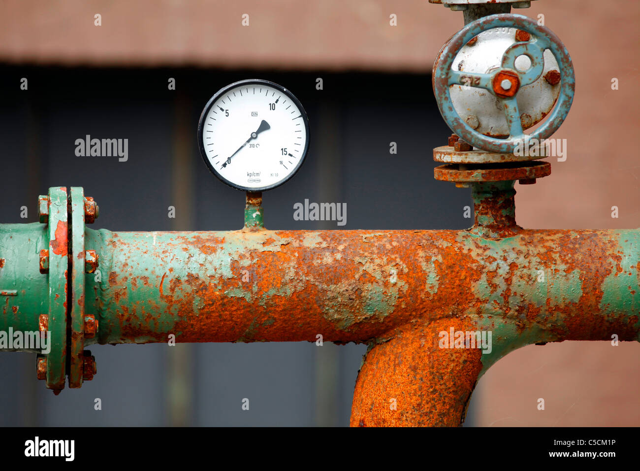 Old and rusty pipes and pressure indicator, of an old and closed industrial complex. Stock Photo
