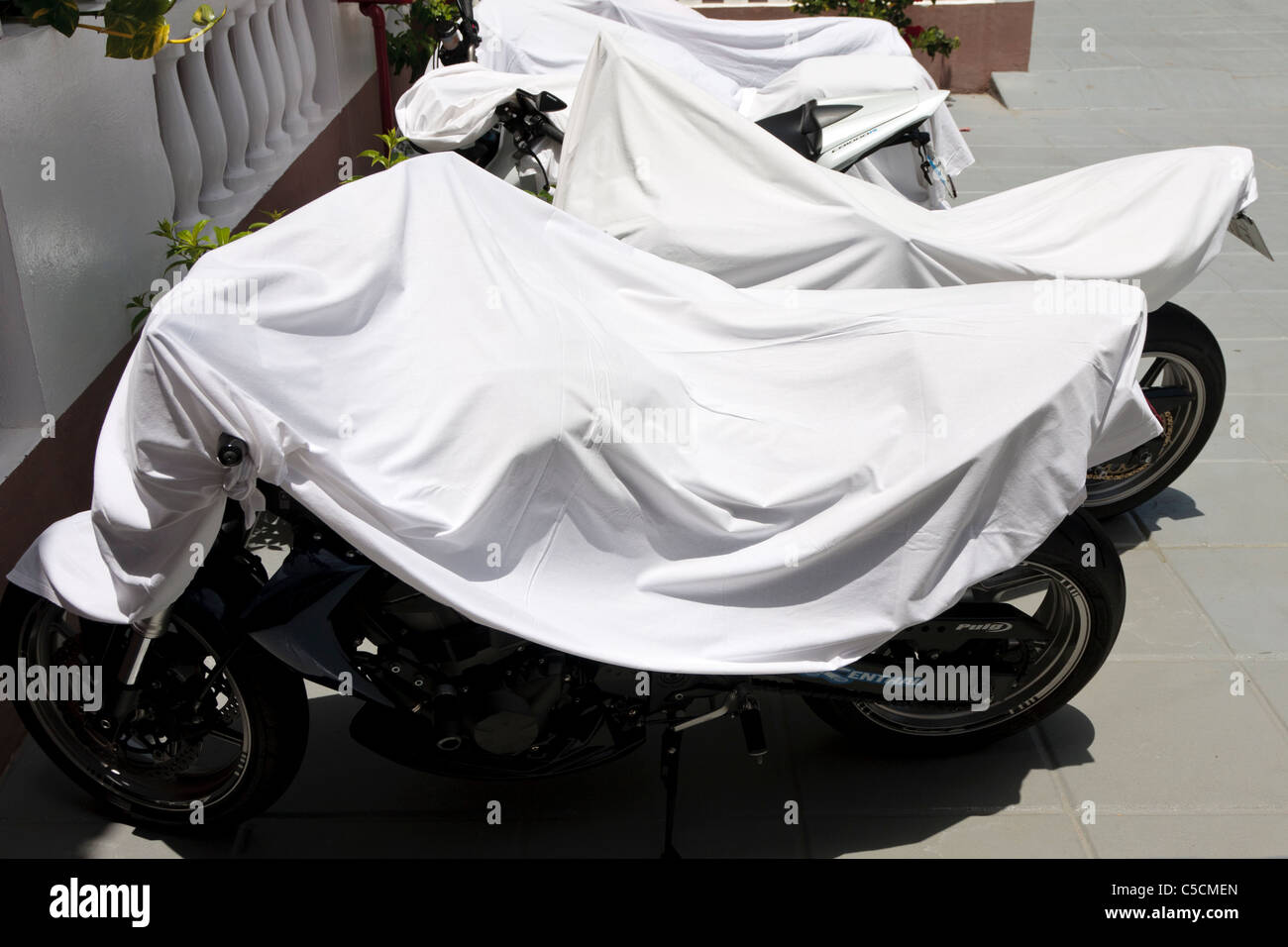 Sheets thrown over motorcycles to keep them cool in the hot summer sun