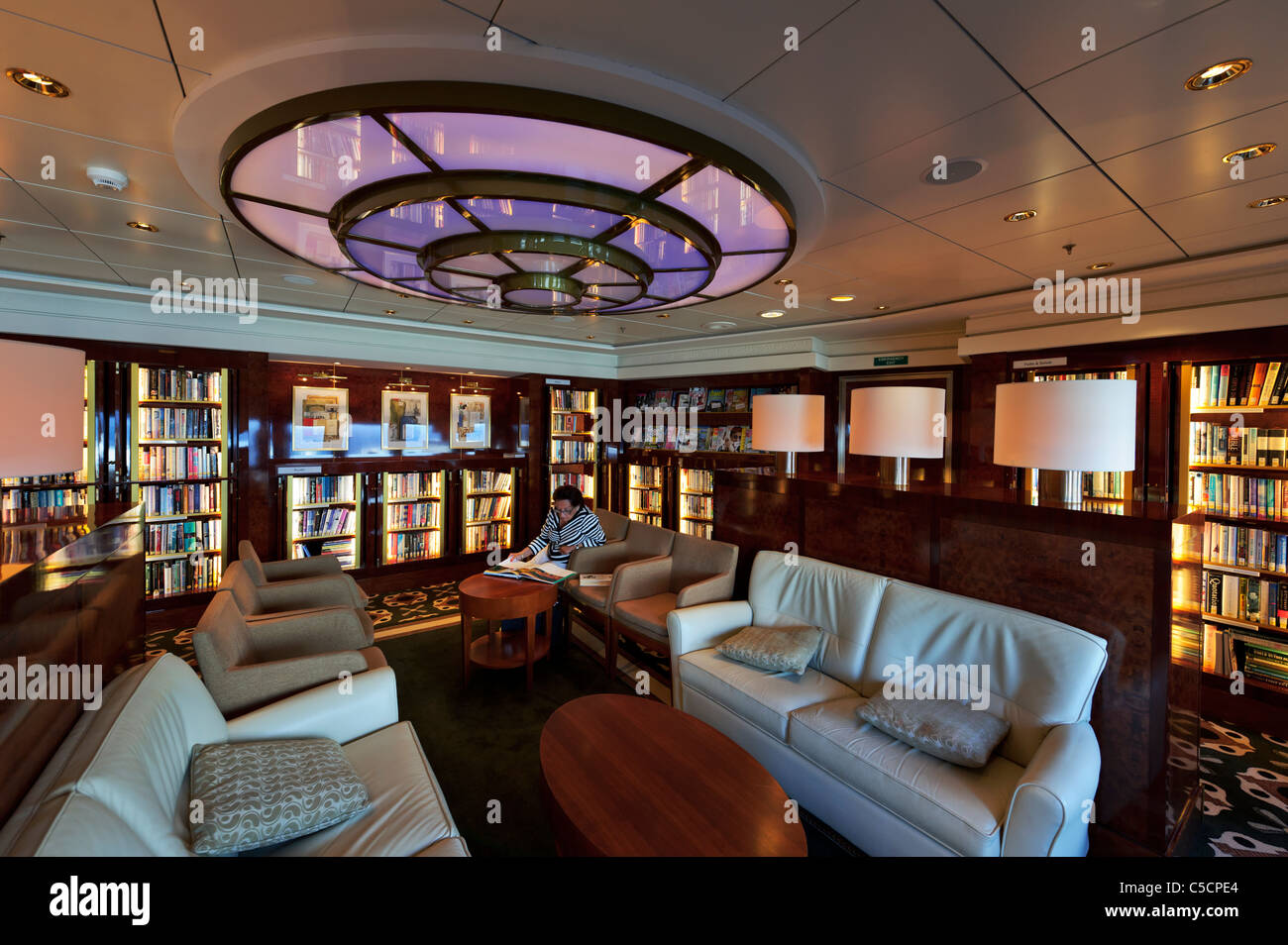 A Passenger reading a book in the Library on the Queen Mary 2 Ocean ...