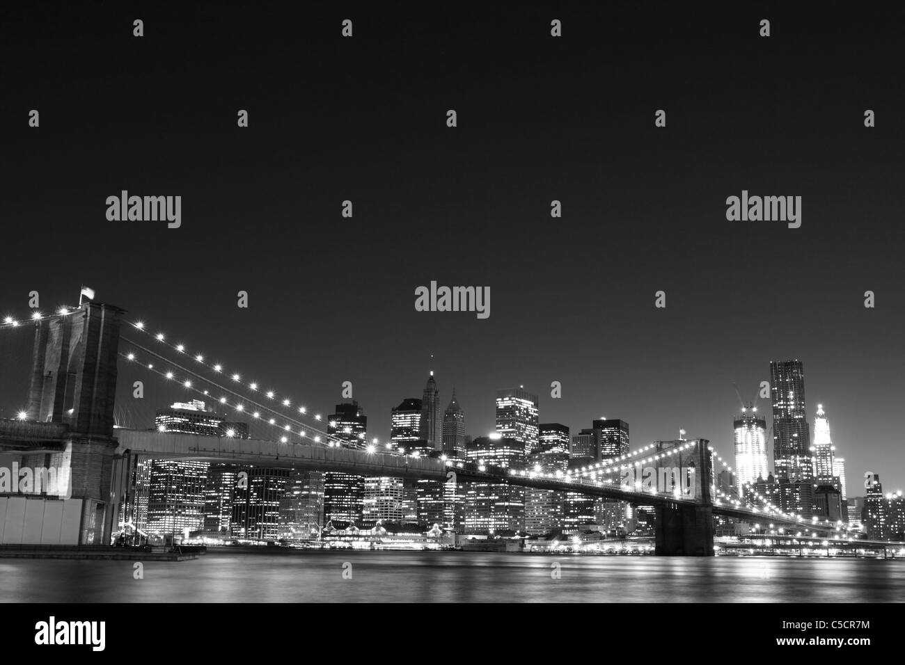 New York City Skyline and Brooklyn Bridge At Night Stock Photo