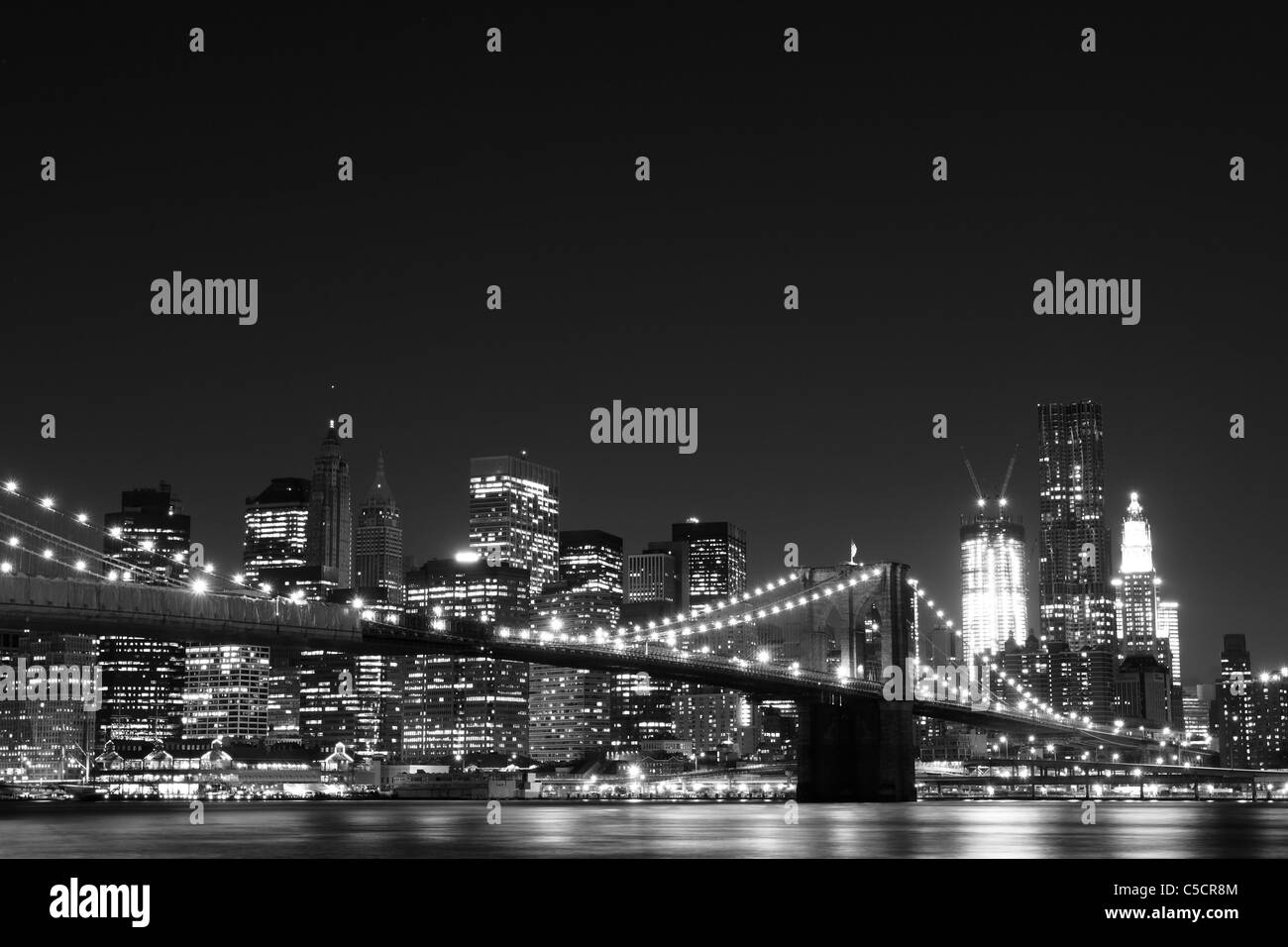 New York City Skyline and Brooklyn Bridge At Night Stock Photo