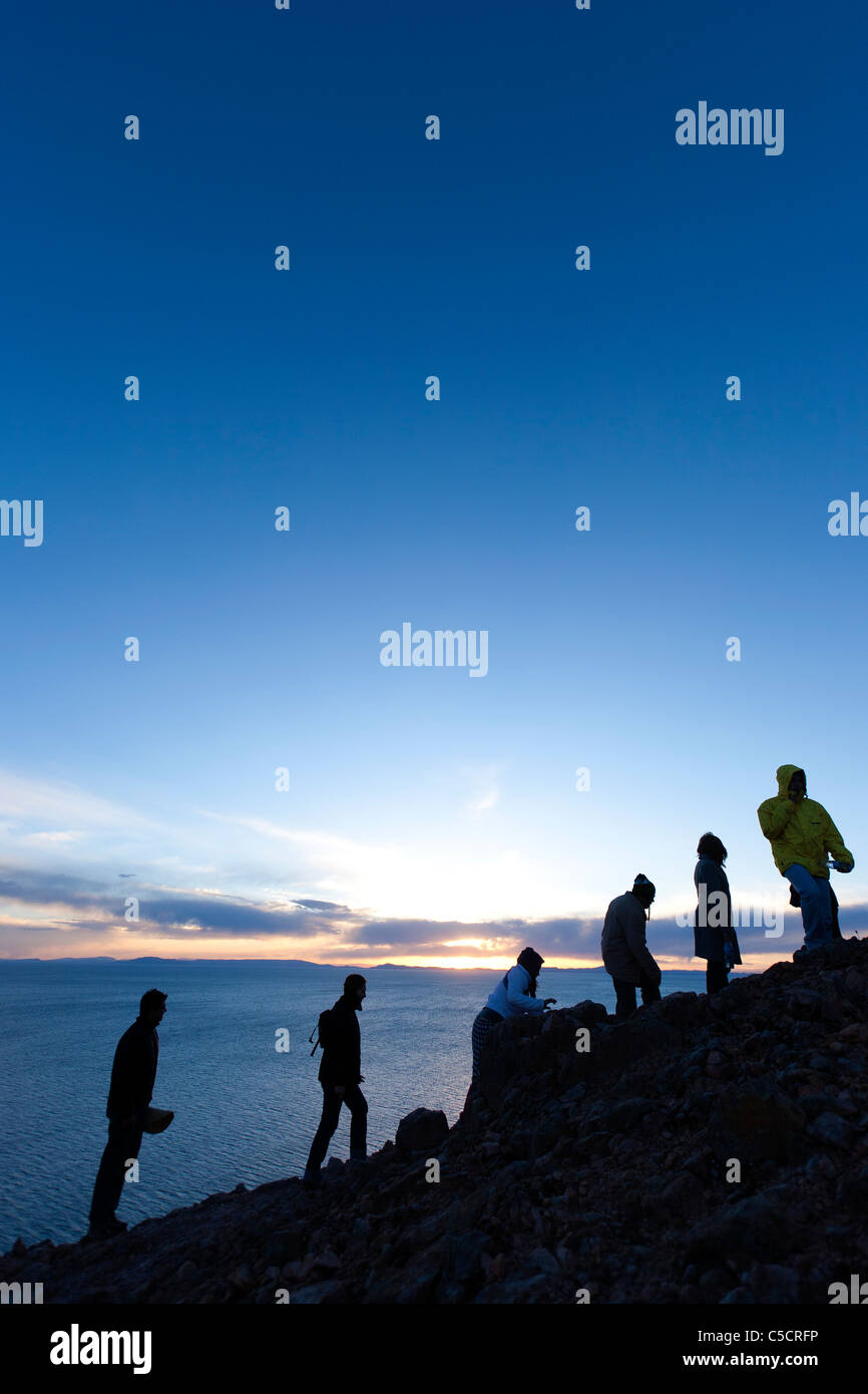 Hikers walking to the top of Suasi to take in the view of Lake Titicaca at sunset, the only private island on the Lake Stock Photo