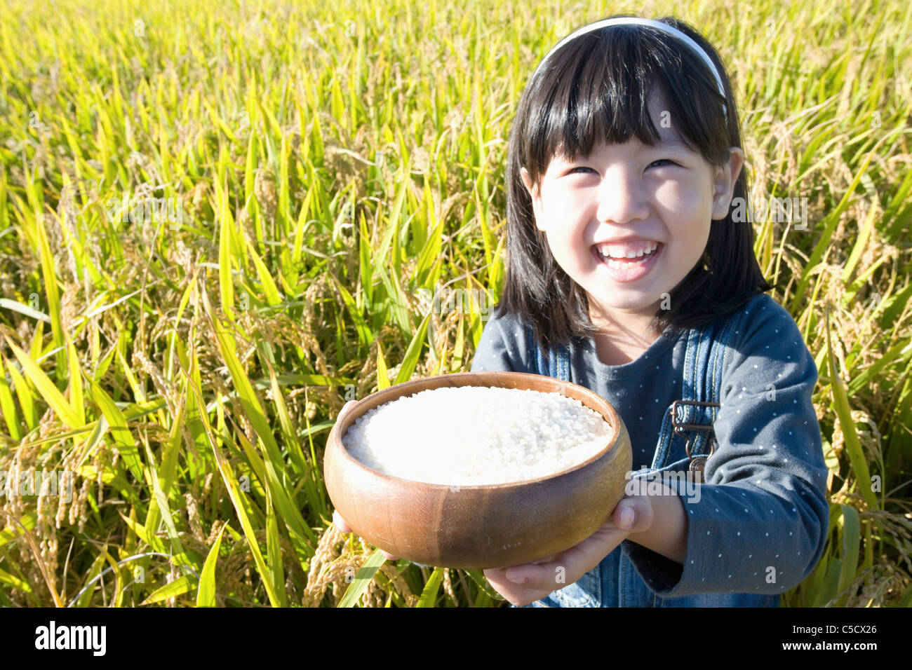 jar filled with rice in girl's hand Stock Photo