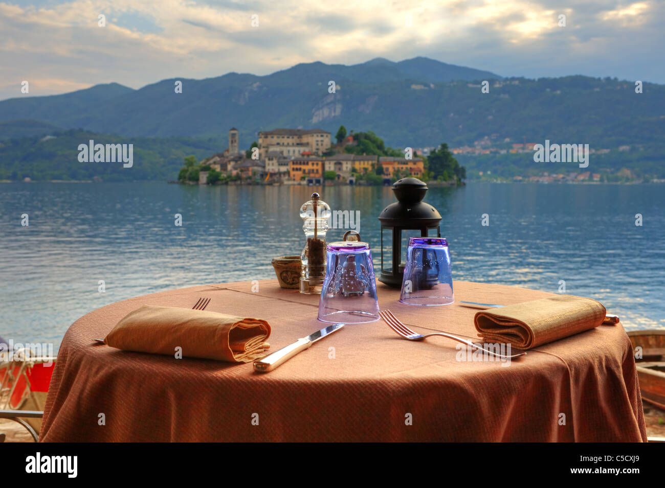 table laid for dinner with views of Lake Orta and the island of San Giulio Stock Photo
