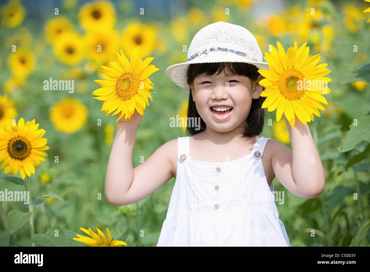 girl holding sunflowers in flower field with big smile Stock Photo - Alamy