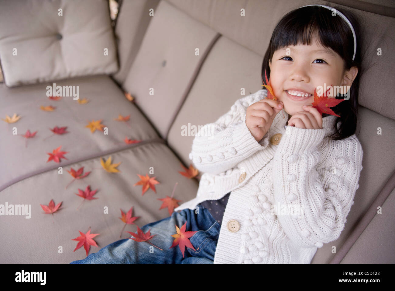 girl holding autumn leaves to her face Stock Photo - Alamy